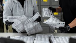 Election workers process mail-in ballots following a primary election at San Francisco County